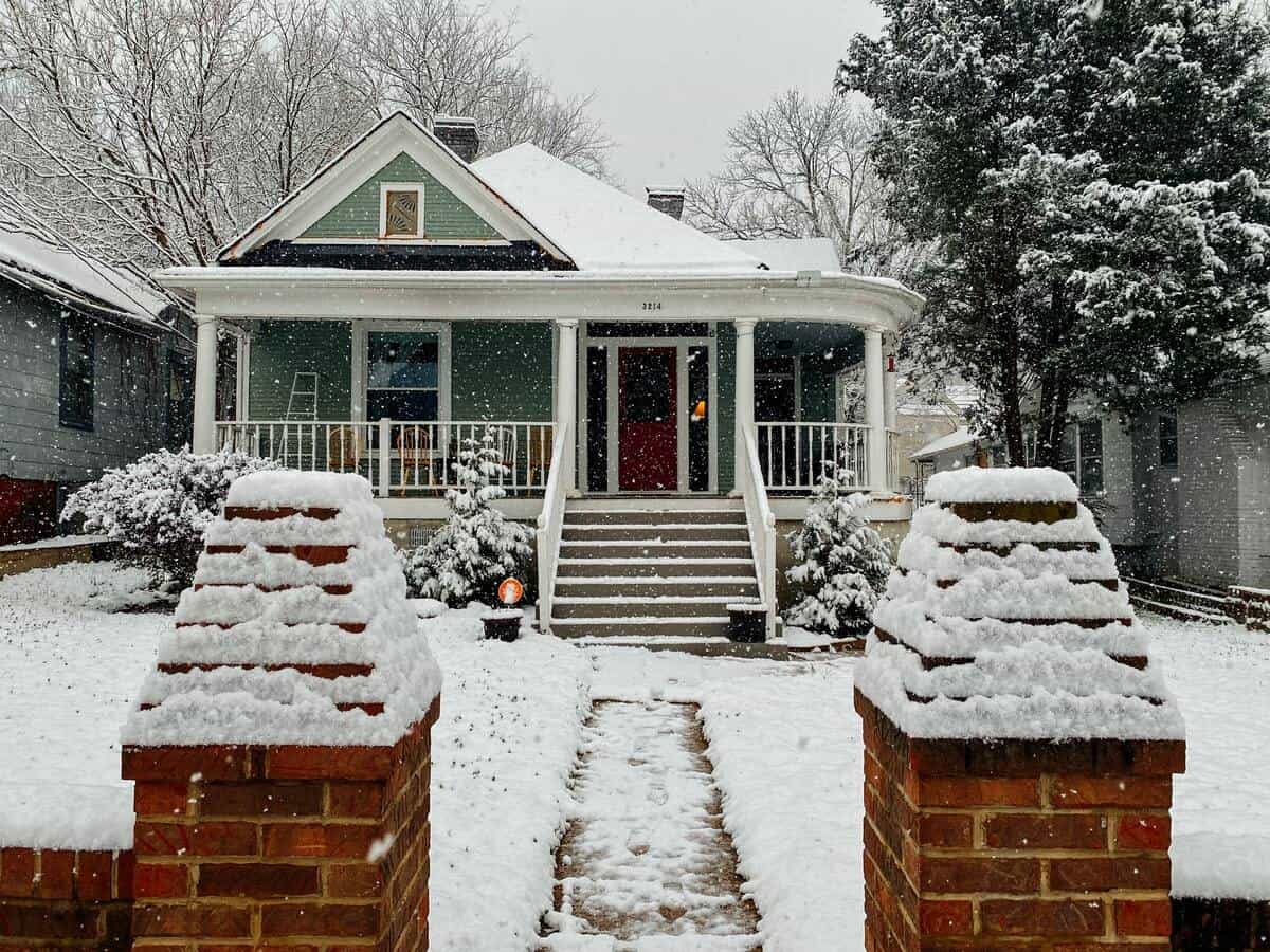 A craftsman style home surrounded by snow.
