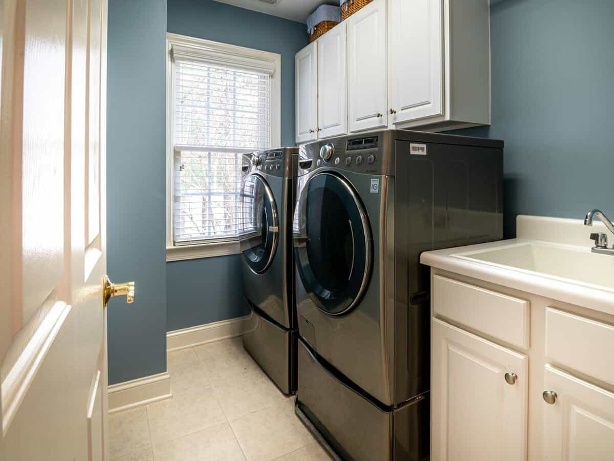 A washing and drying machine inside of a home's laundry room.
