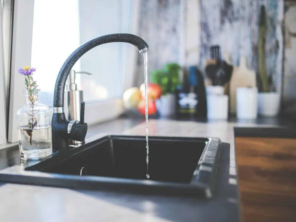 Water coming through a faucet at a kitchen sink.