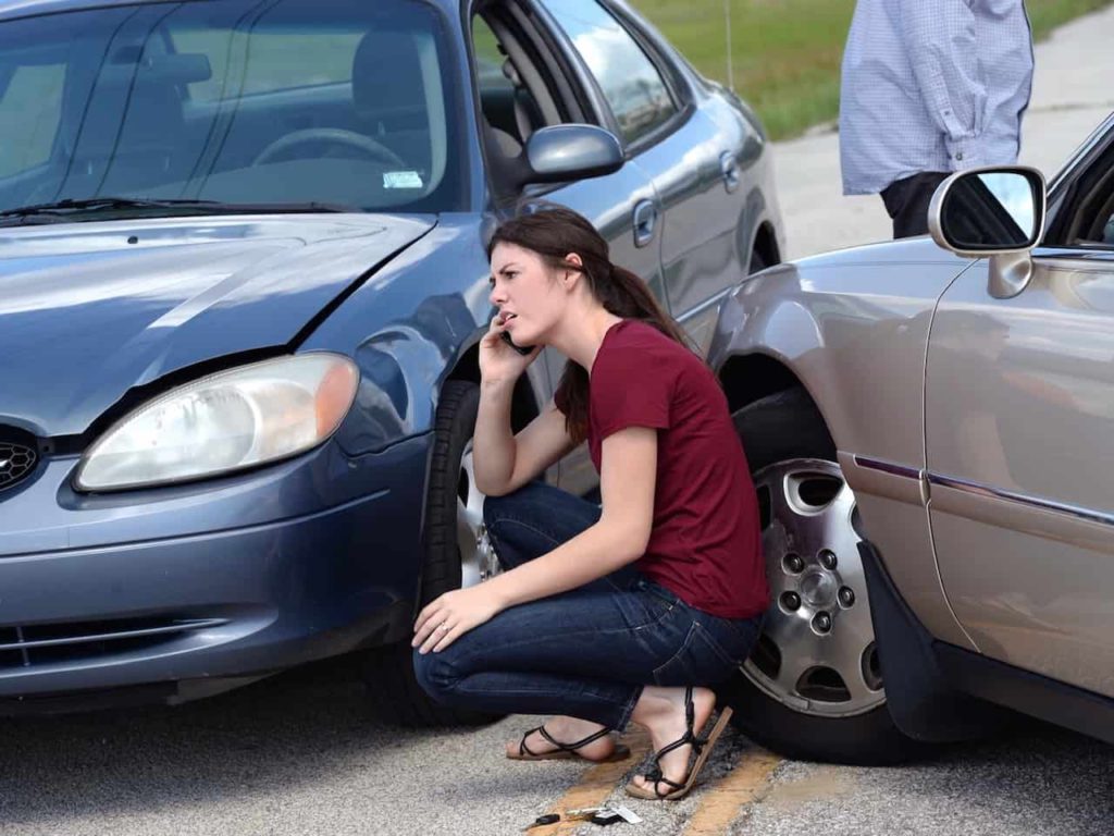 Young woman making phone call after accident