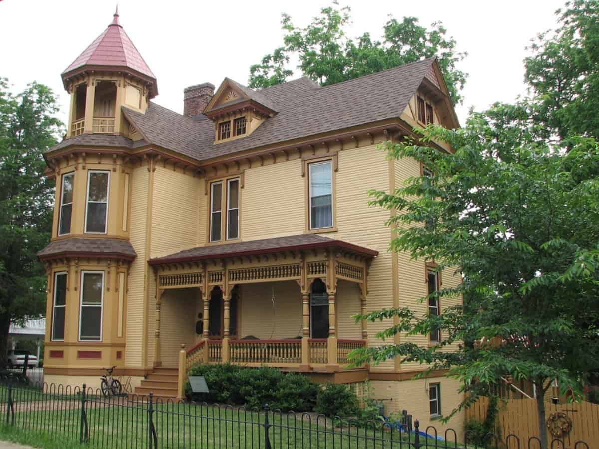 an older home on a corner, victorian style, brown home