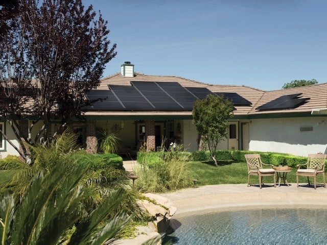 one story home with pool solar panels on roof