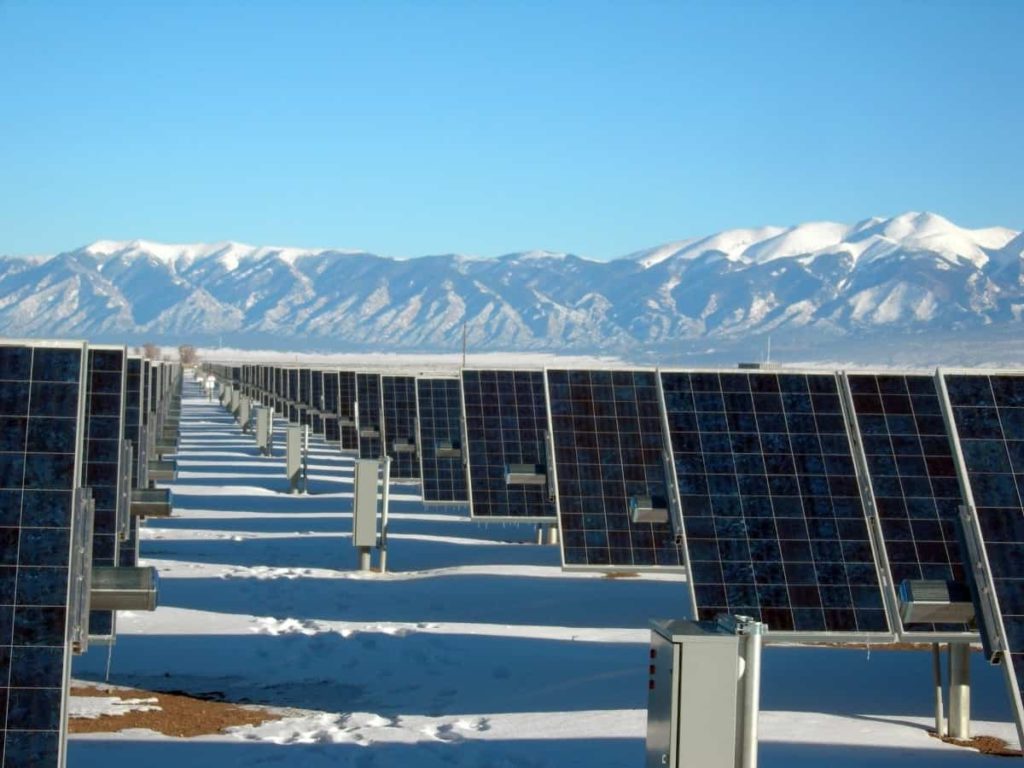 solar panels with a blue sky and mountains in the background