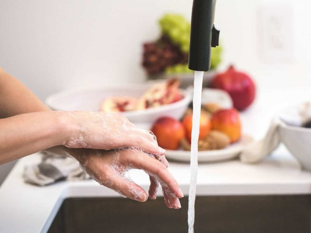 black faucet with fruit in the background