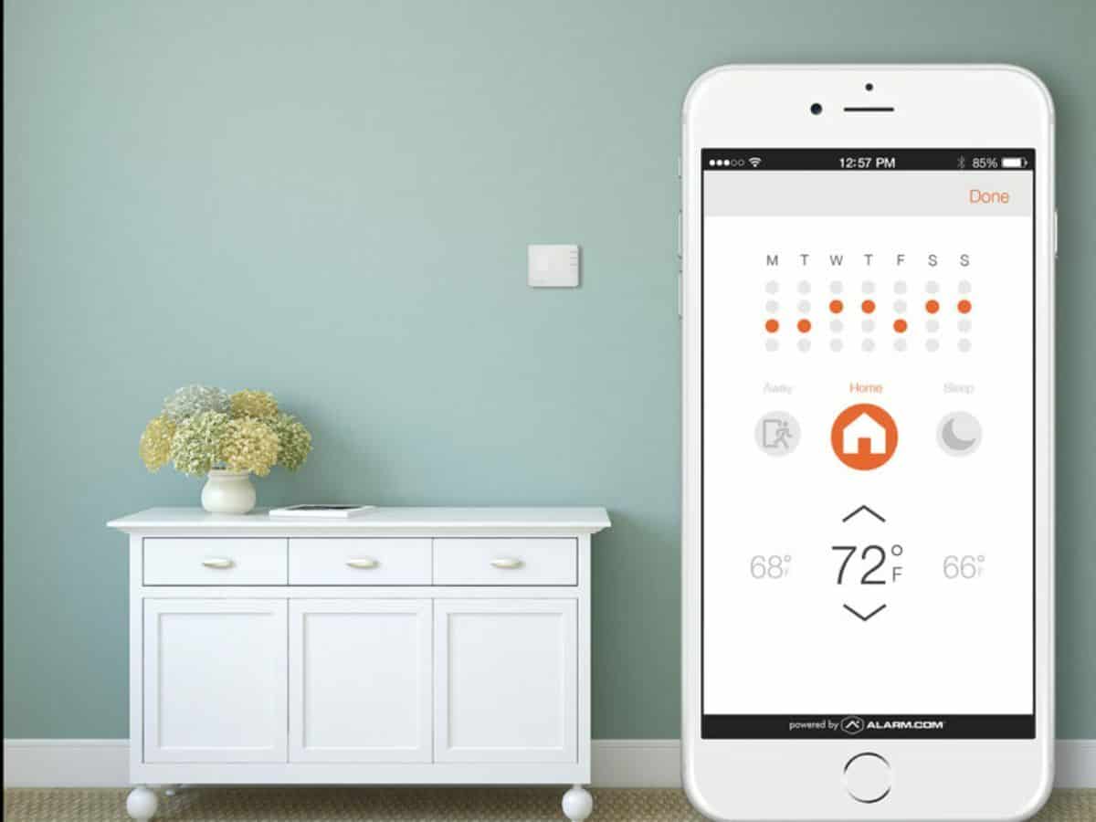 alarm.com smart home app against home wall