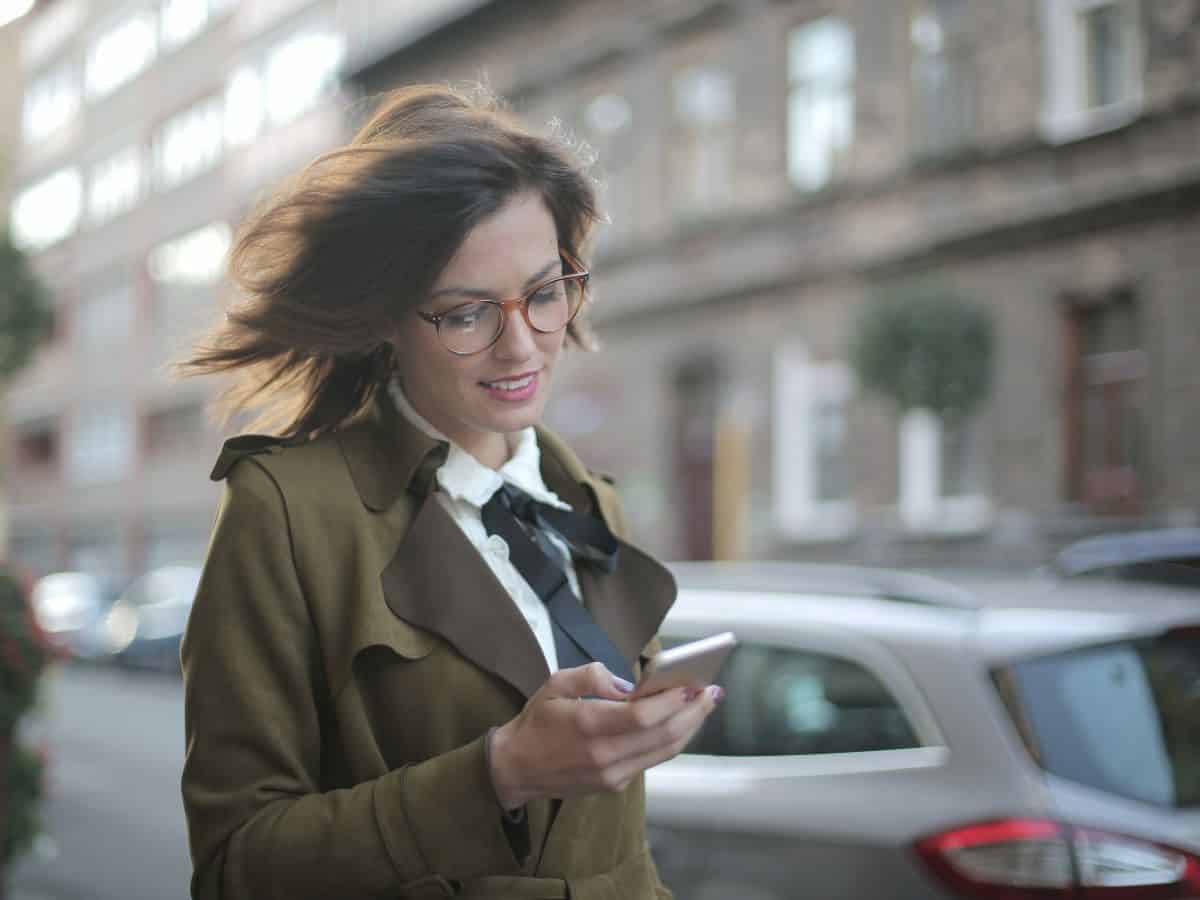 woman walking and checking her phone