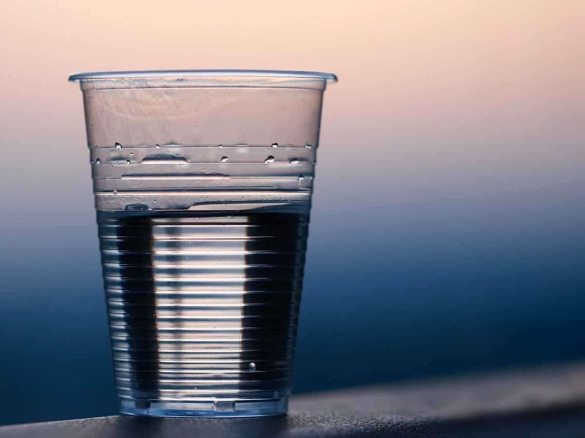 a cup of water against a sunset