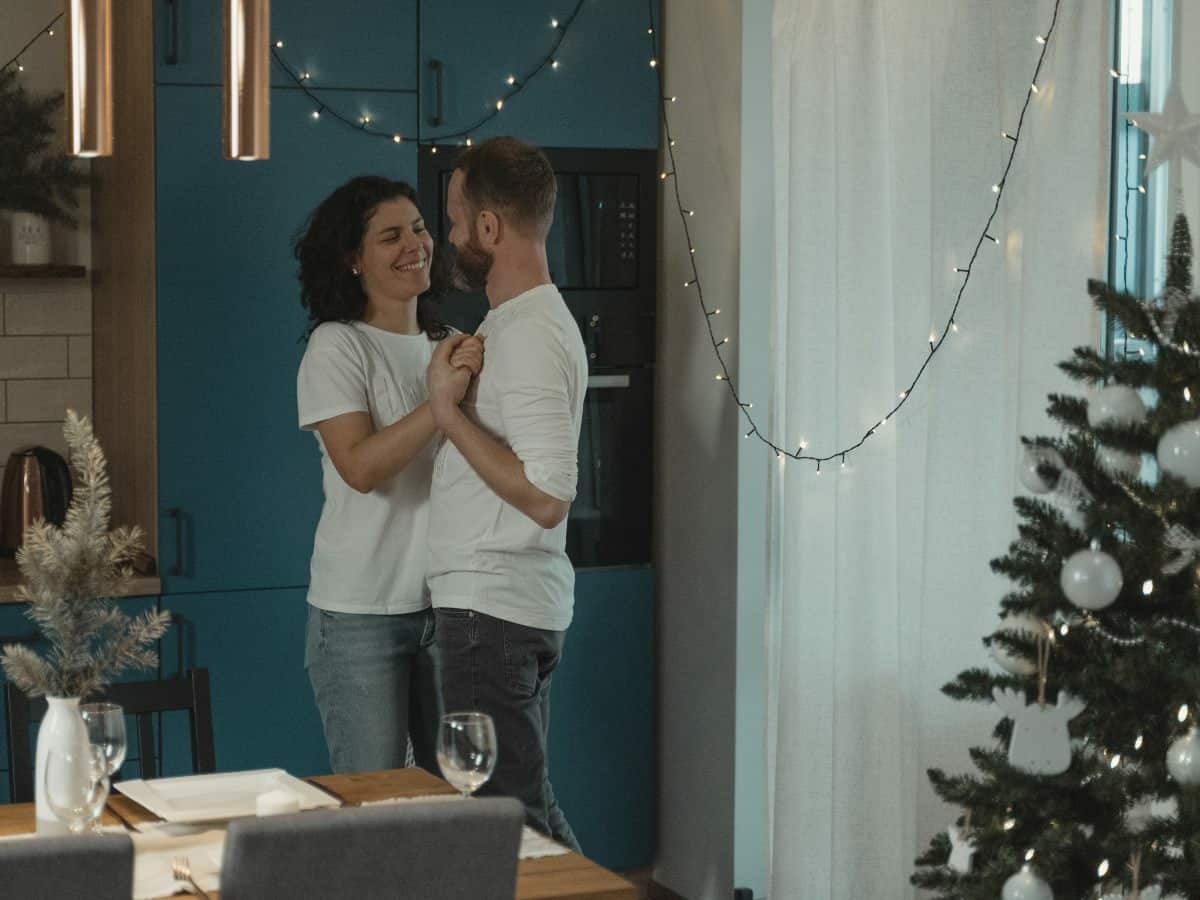 couple dancing in room with christmas tree