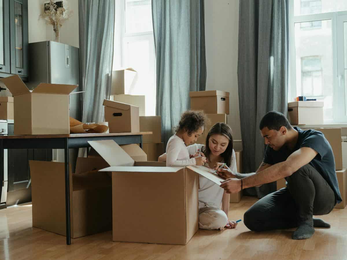 family of three unpacking boxes in home