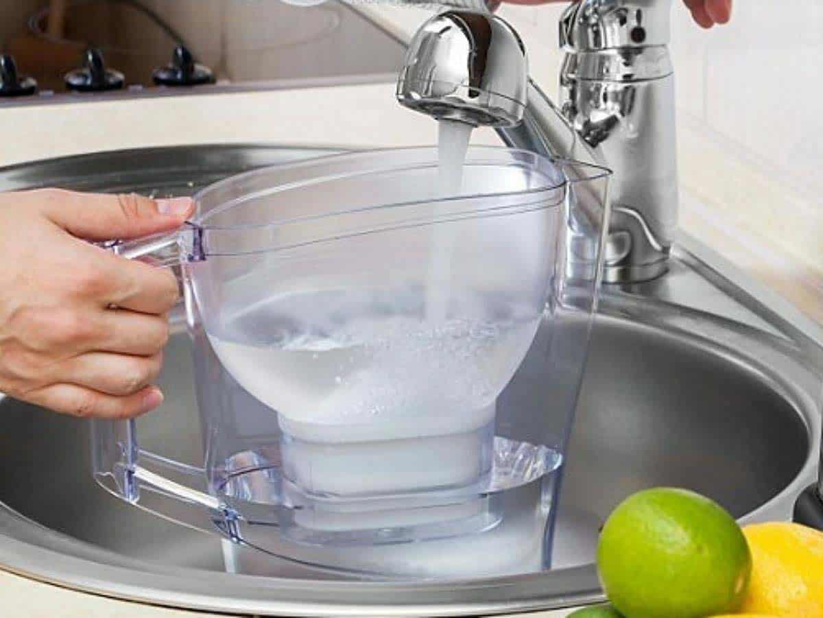 filling a water pitcher with limes in the corner