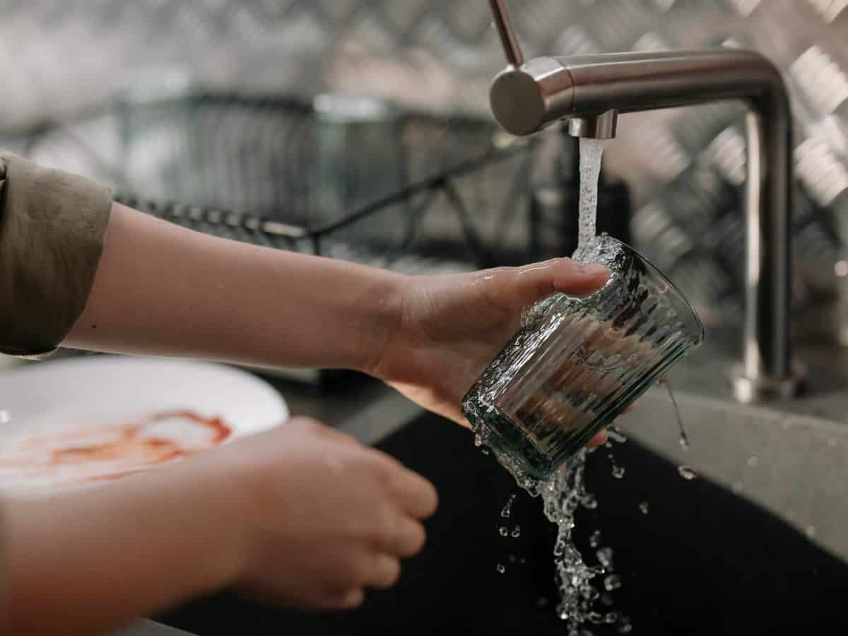 washing a dish in the sink with tap water