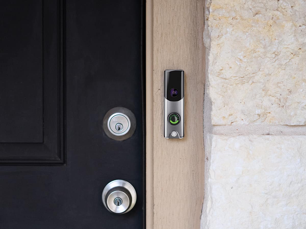 A silver Skybell doorbell camera is installed next to a black front door.