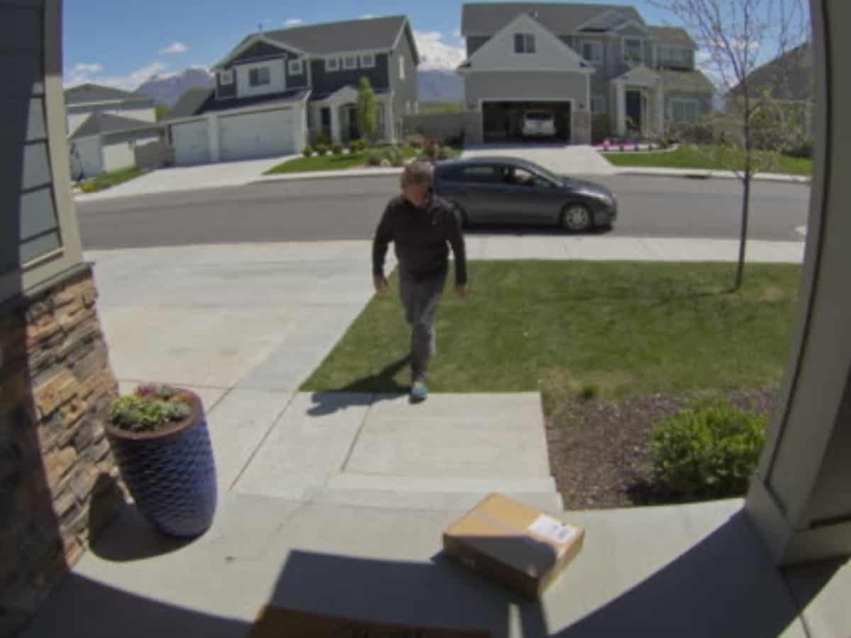 doorbell camera footage of package theft, car in background
