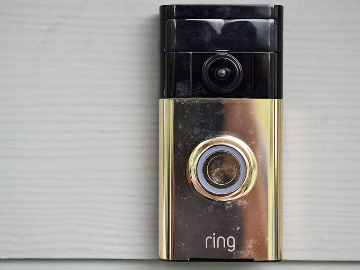 a gold ring doorbell camera against white wall