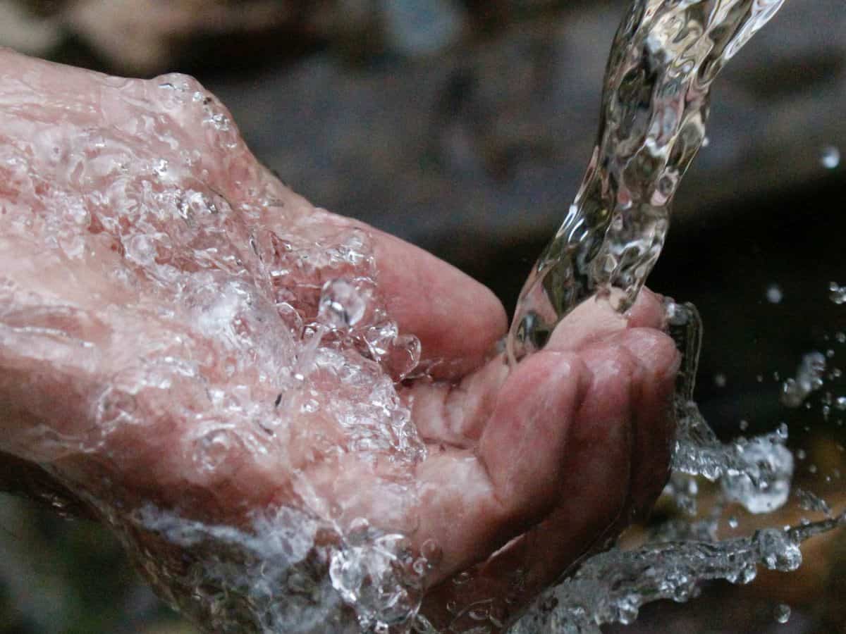 water stream falling into the palm of someones hand
