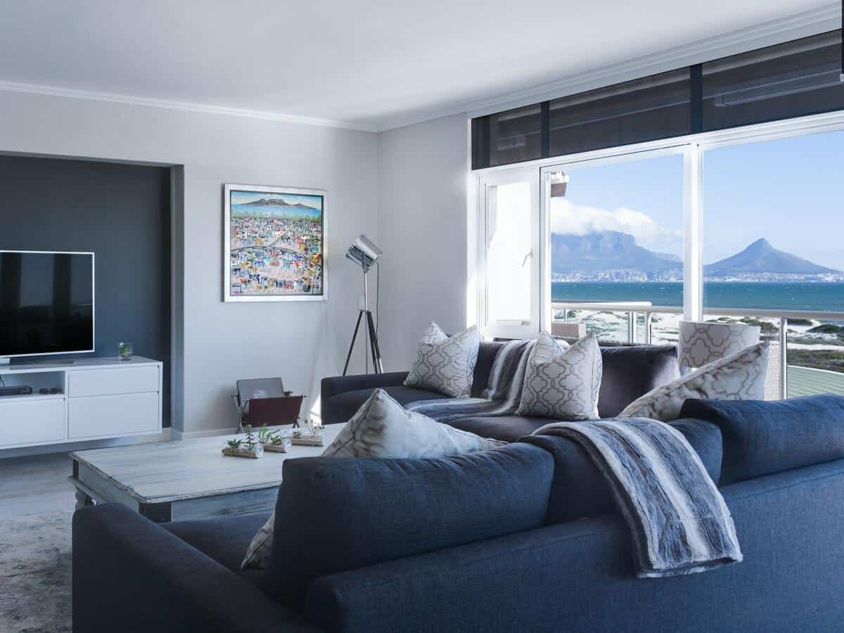 A living room with two dark grey sofas facing a coffee table and flat screen television.