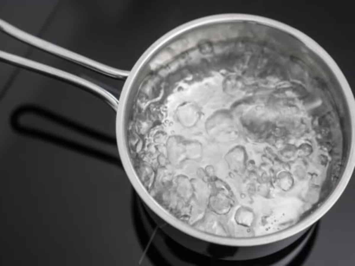 Water boiling in a small pan. Shot from up and in slow motion