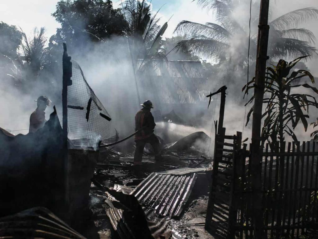 burned down home with smoke in the air