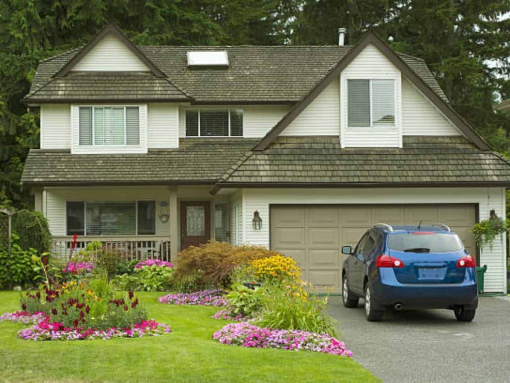 blue car in the driveway of a home