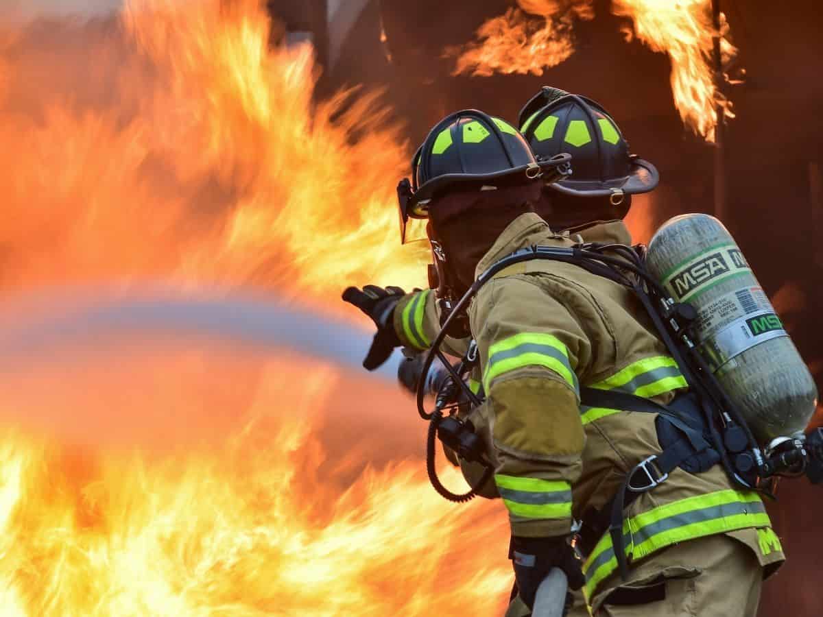 two firefighters trying to fight a fire