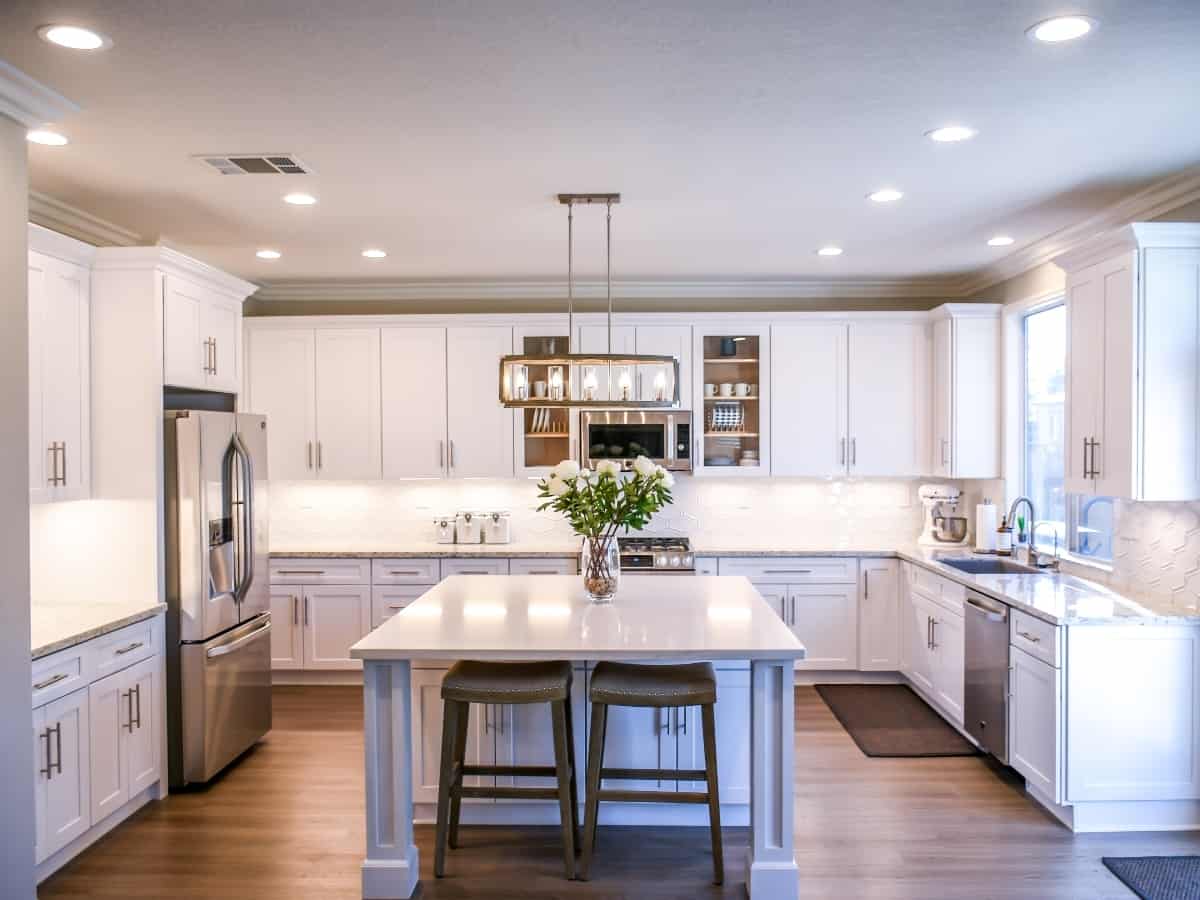 all white kitchen with modern appliances and bright lights