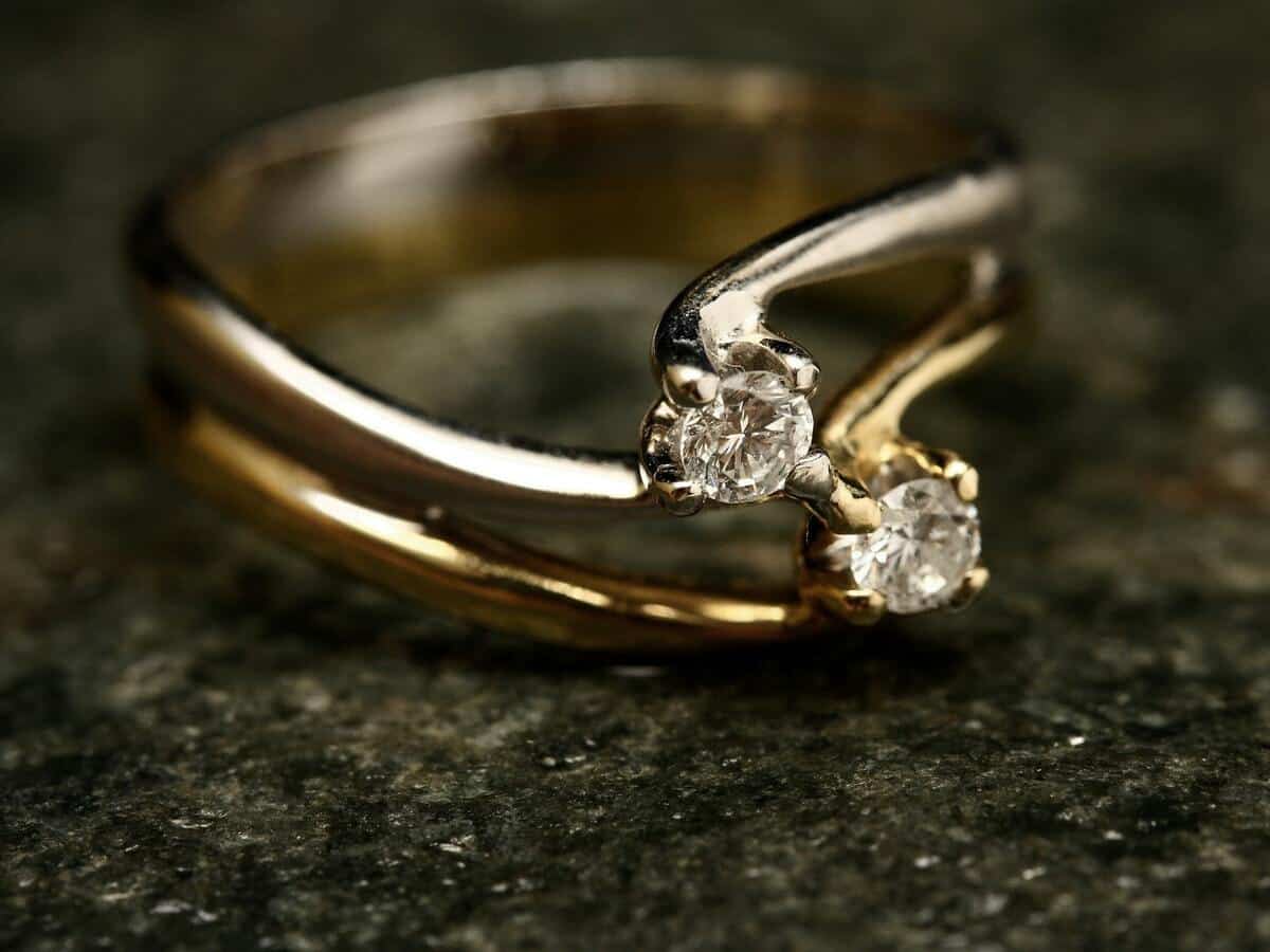 A gold ring with diamonds on top of a dark green counter.