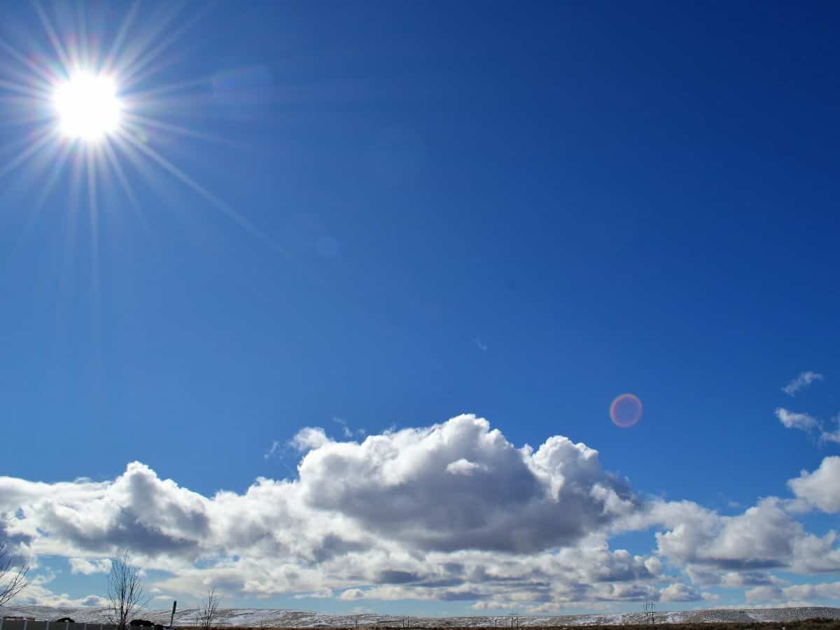 the sun in the corner with clouds and blue sky