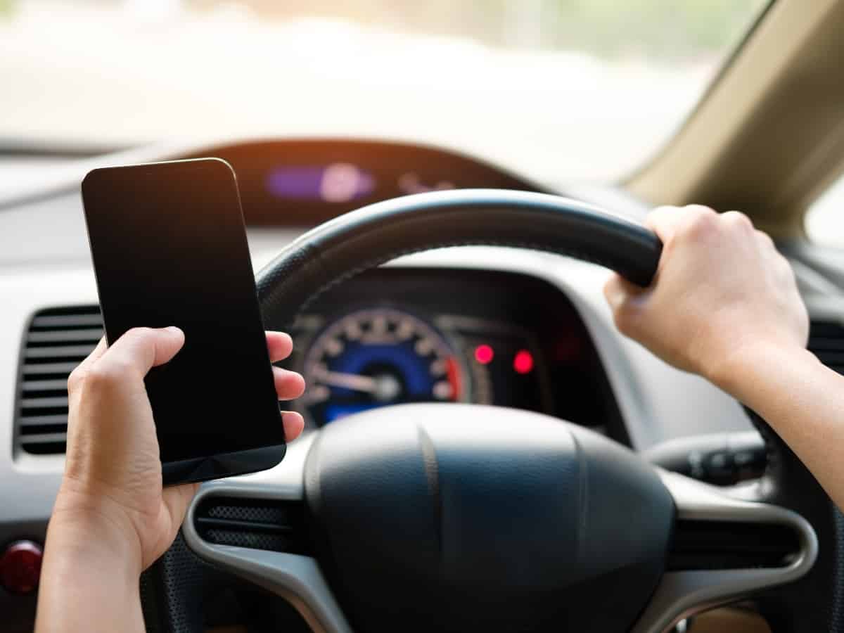 Hand holding phone while driving