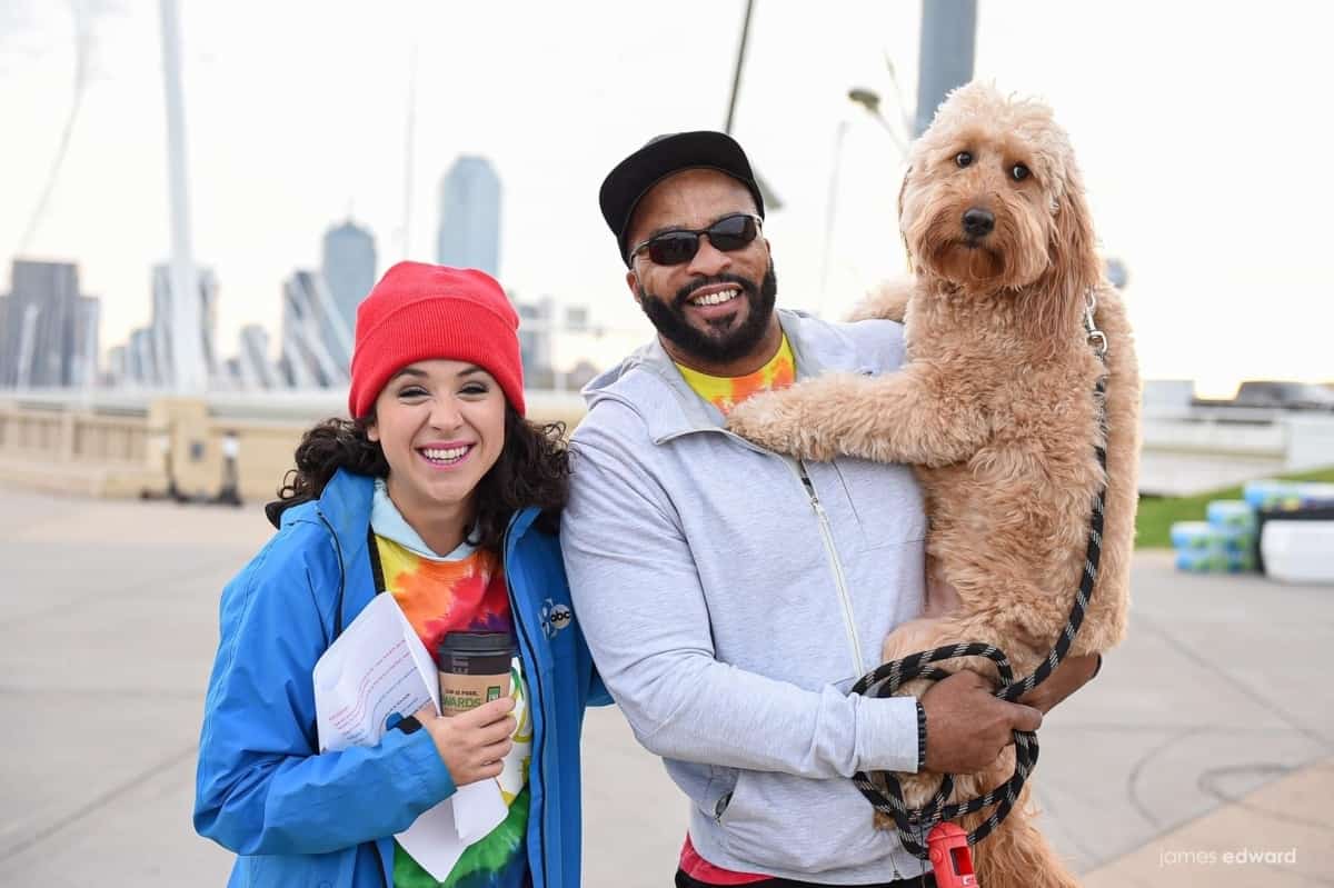 A man holding a Goldendoodle poses with a woman at a Cancer Support Community North Texas event.