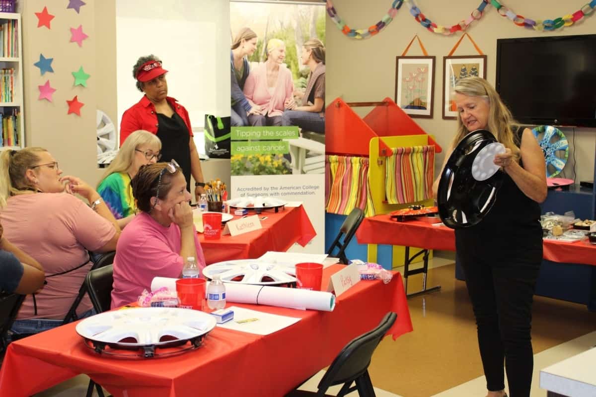 A woman is leading instruction at a group class inside of a Cancer Support Community North Texas clubhouse.