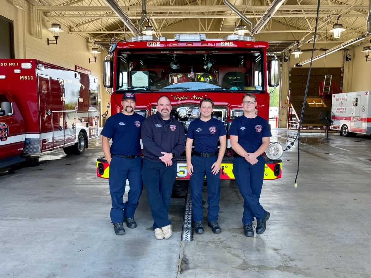Four firefighters from Argyle, Texas Fire Station #511 stand in front of a firetruck.