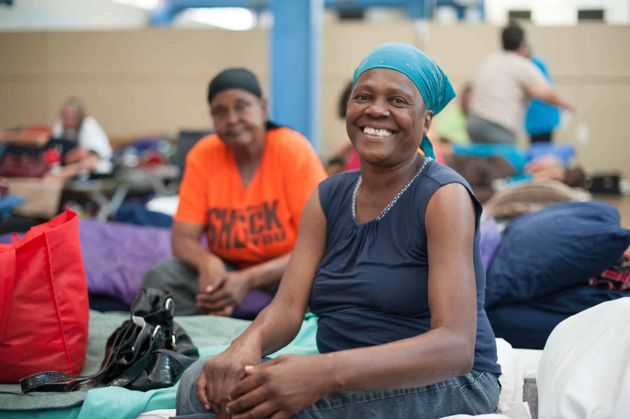 A client from Austin Street Center is smiling while sitting inside the facility.