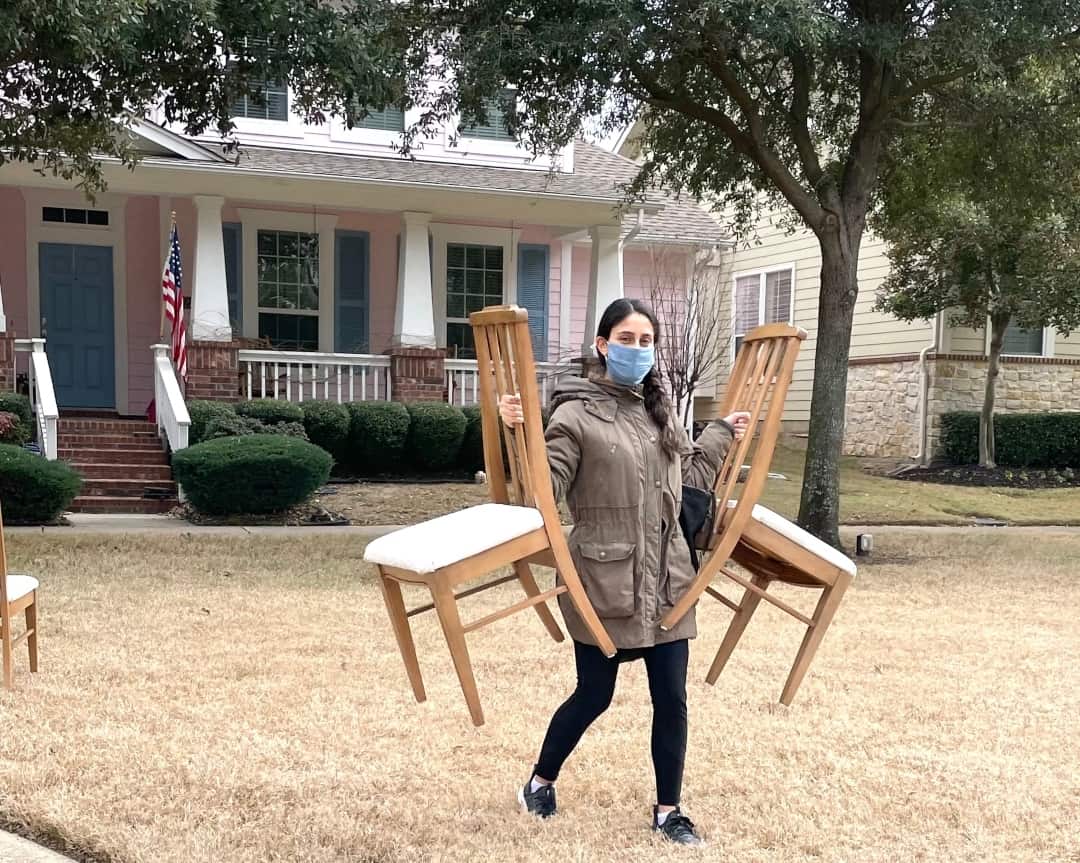 Lena Vu of Offbeat Collective carries vintage chairs used for her business.