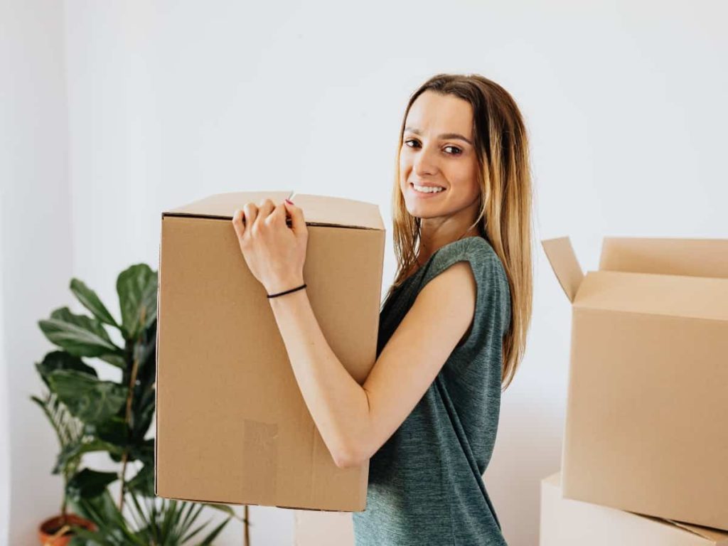 a woman holding a box for a new home