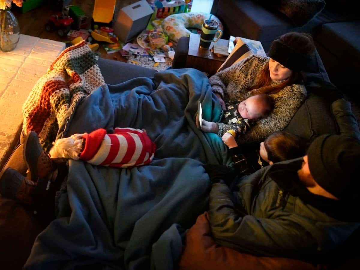 family sitting together during a rolling blackout without power
