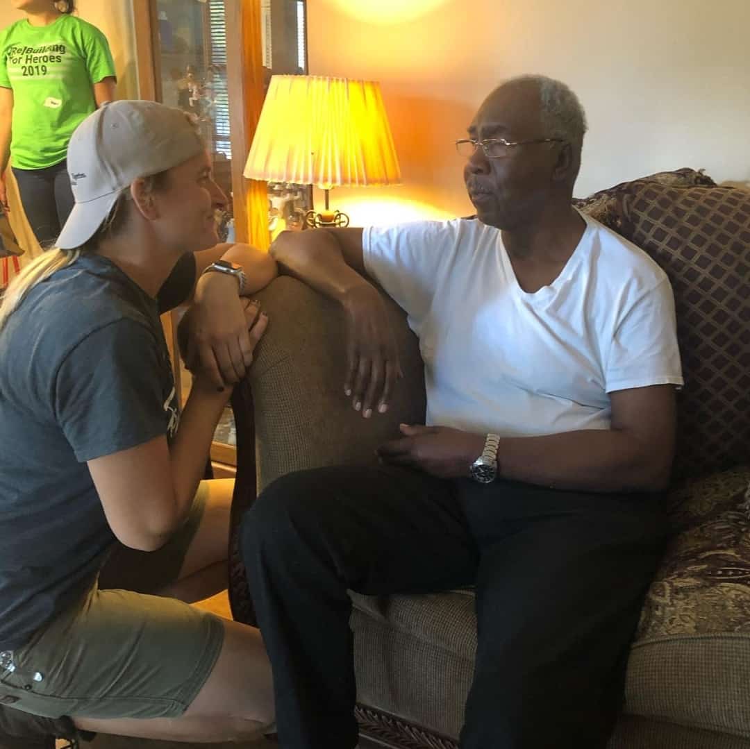 Tia LaFavor of Rebuilding Together North Texas speaks to a client inside of a home.