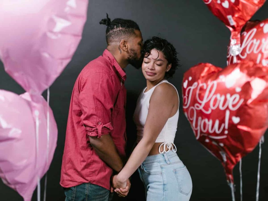 a couple on valentines day with pink and red balloons