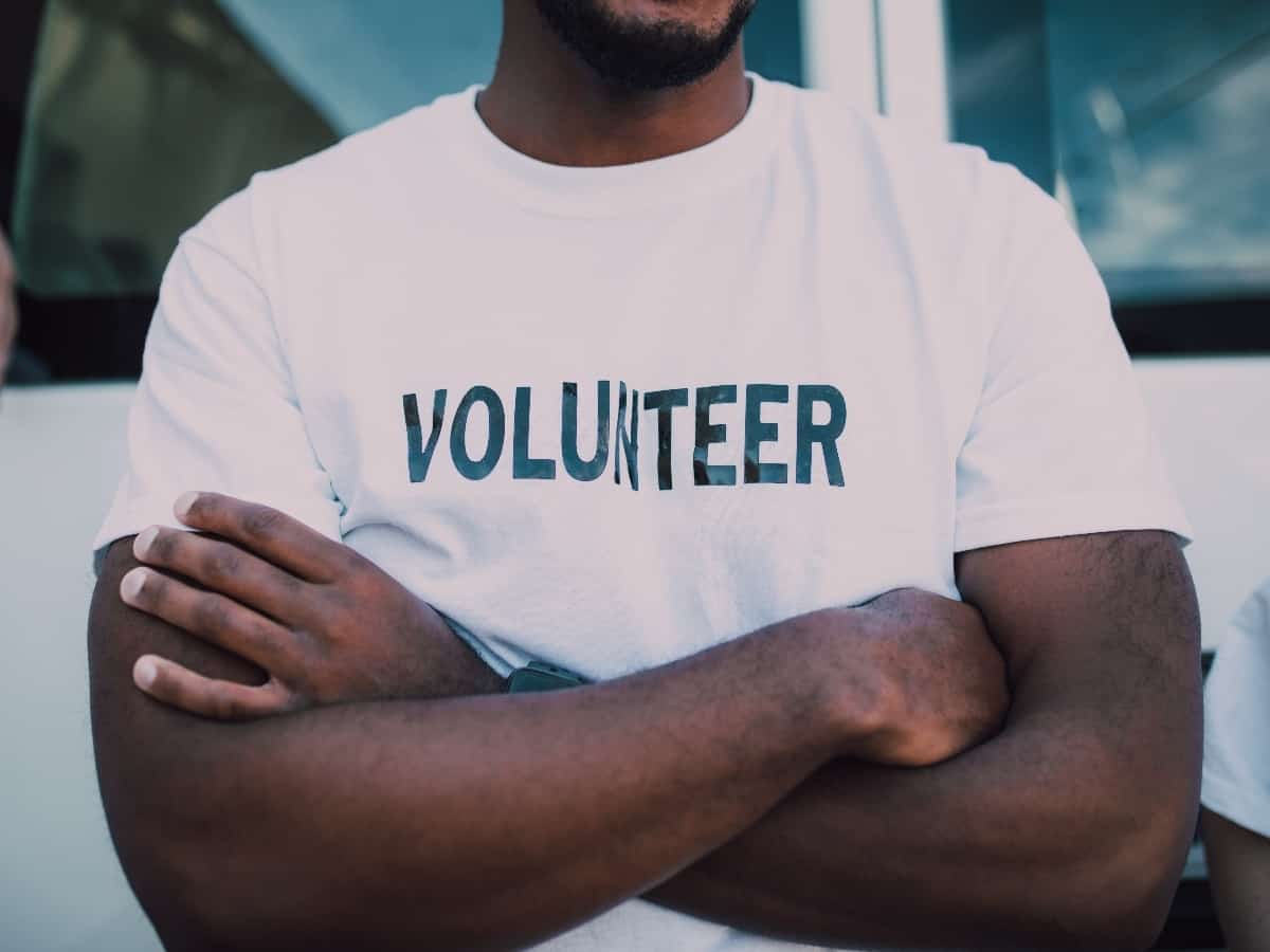man with his arms crossed wearing a volunteer shirt