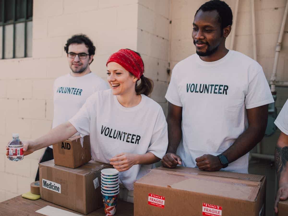 three people volunteering to pass out donated food