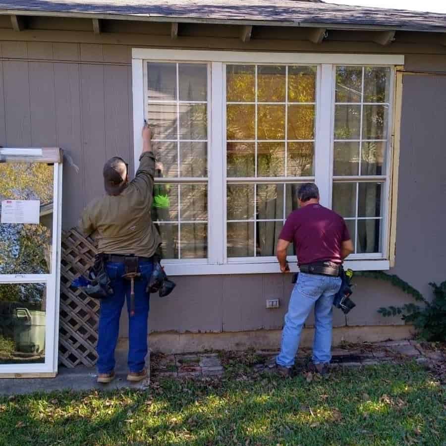 Contractors are working outside of a home on a window replacement for Rebuilding Together North Texas.