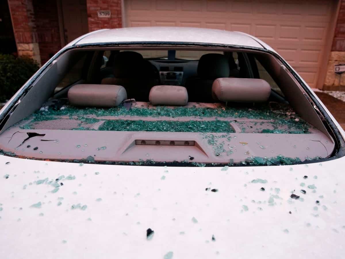 hail damage that results in shattered windshield on white car