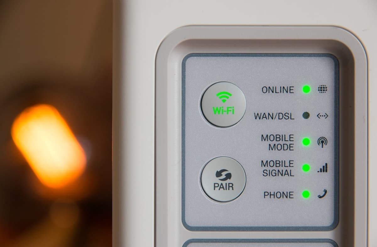 A white modem has various green lights to display its Wi-Fi and phone connection.