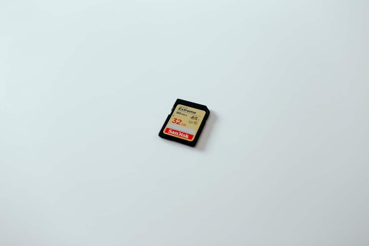 A black SD card is lying on a light blue surface.