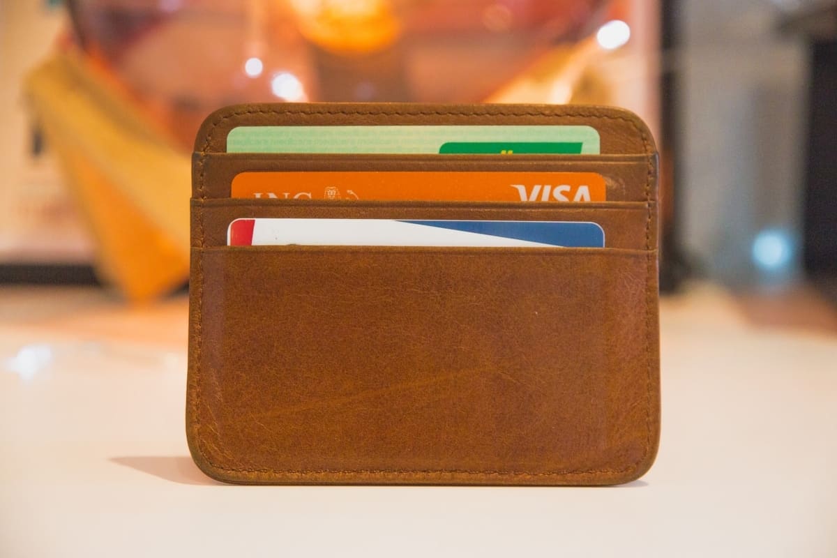 A brown leather wallet displaying credit cards.