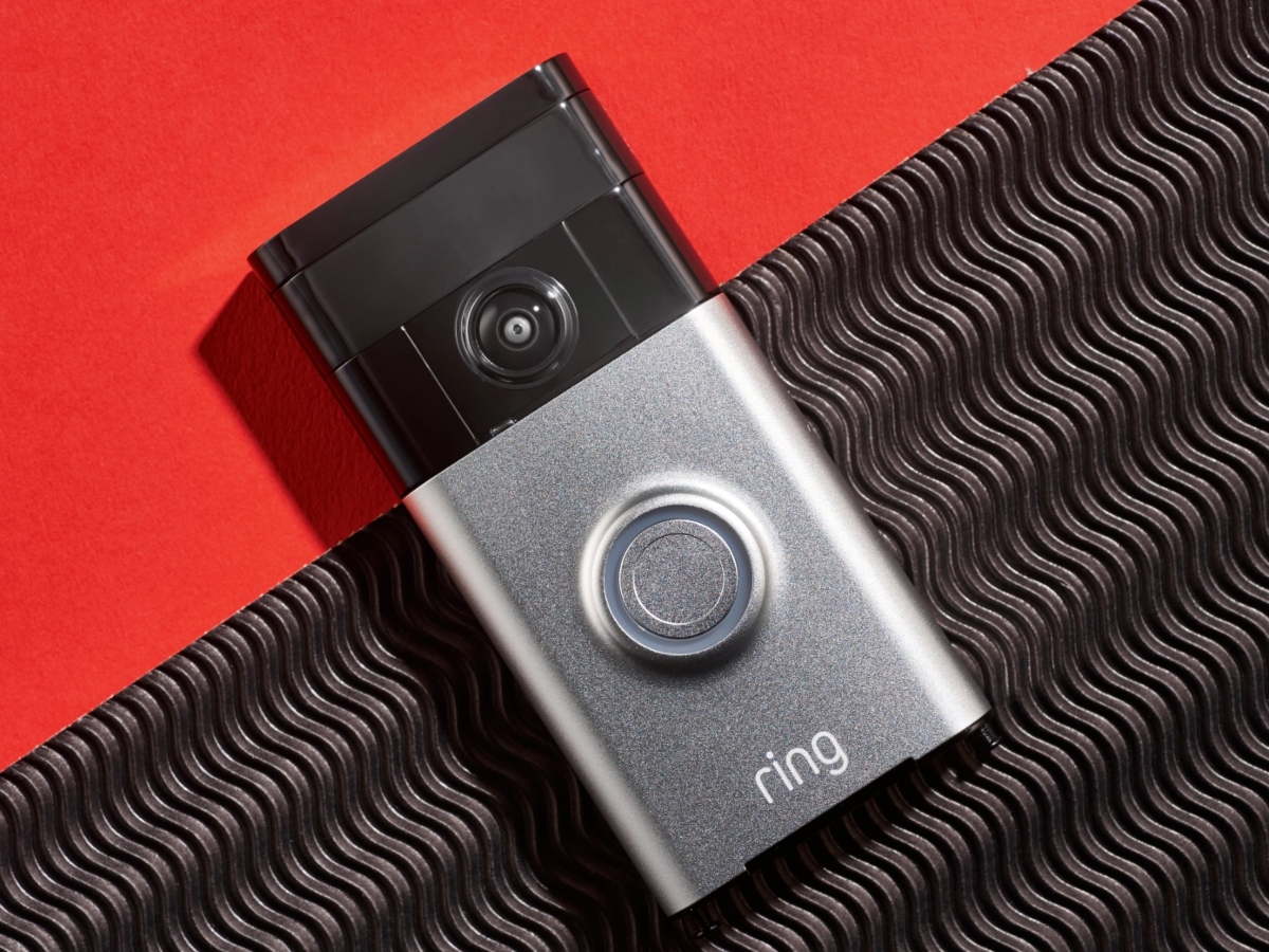 a close up of a ring doorbell against a red and black background