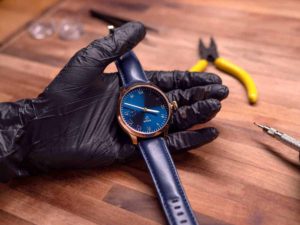 a gloved hand holding a watch