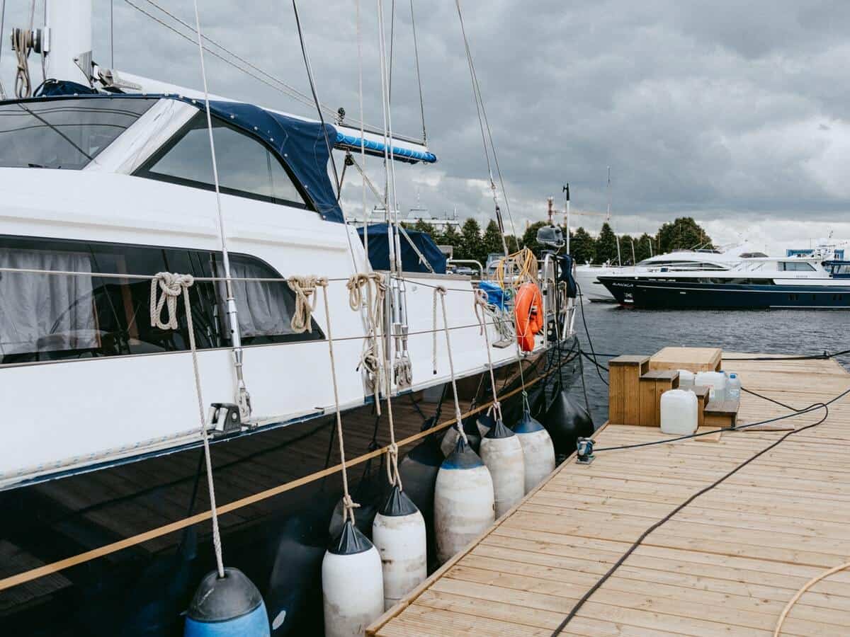 A navy blue and white boat is at a dock.