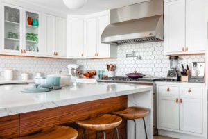 A bright stylish kitchen with a white marble counter and midcentury modern decor.