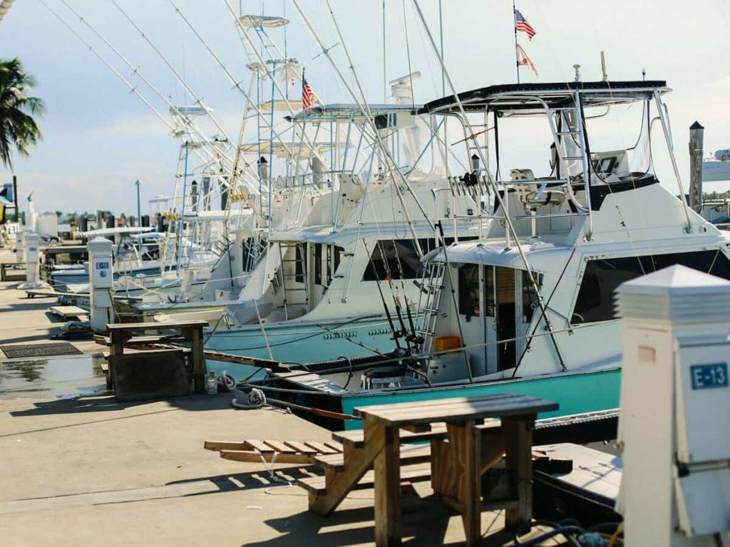 The back of boats lined up at a dock.