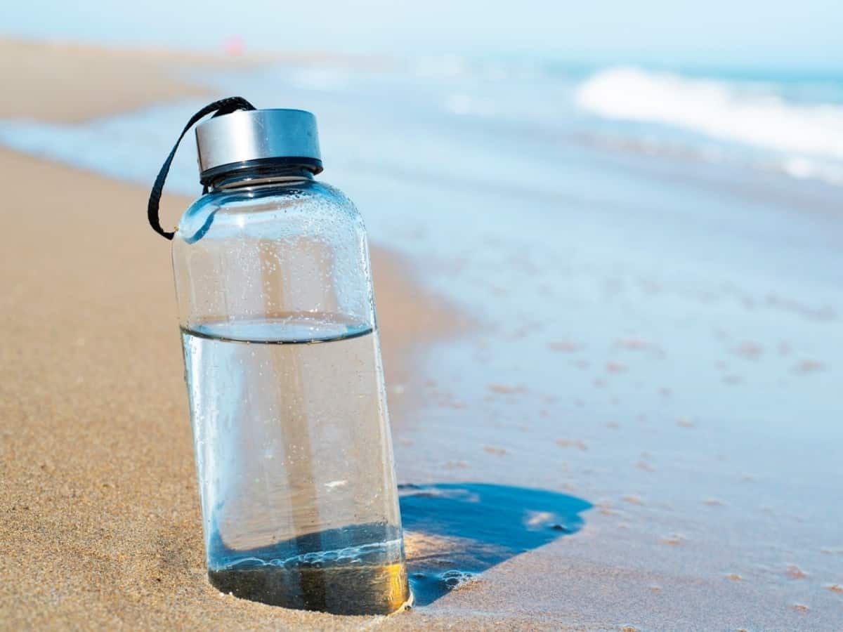 glass water bottle in the sand 